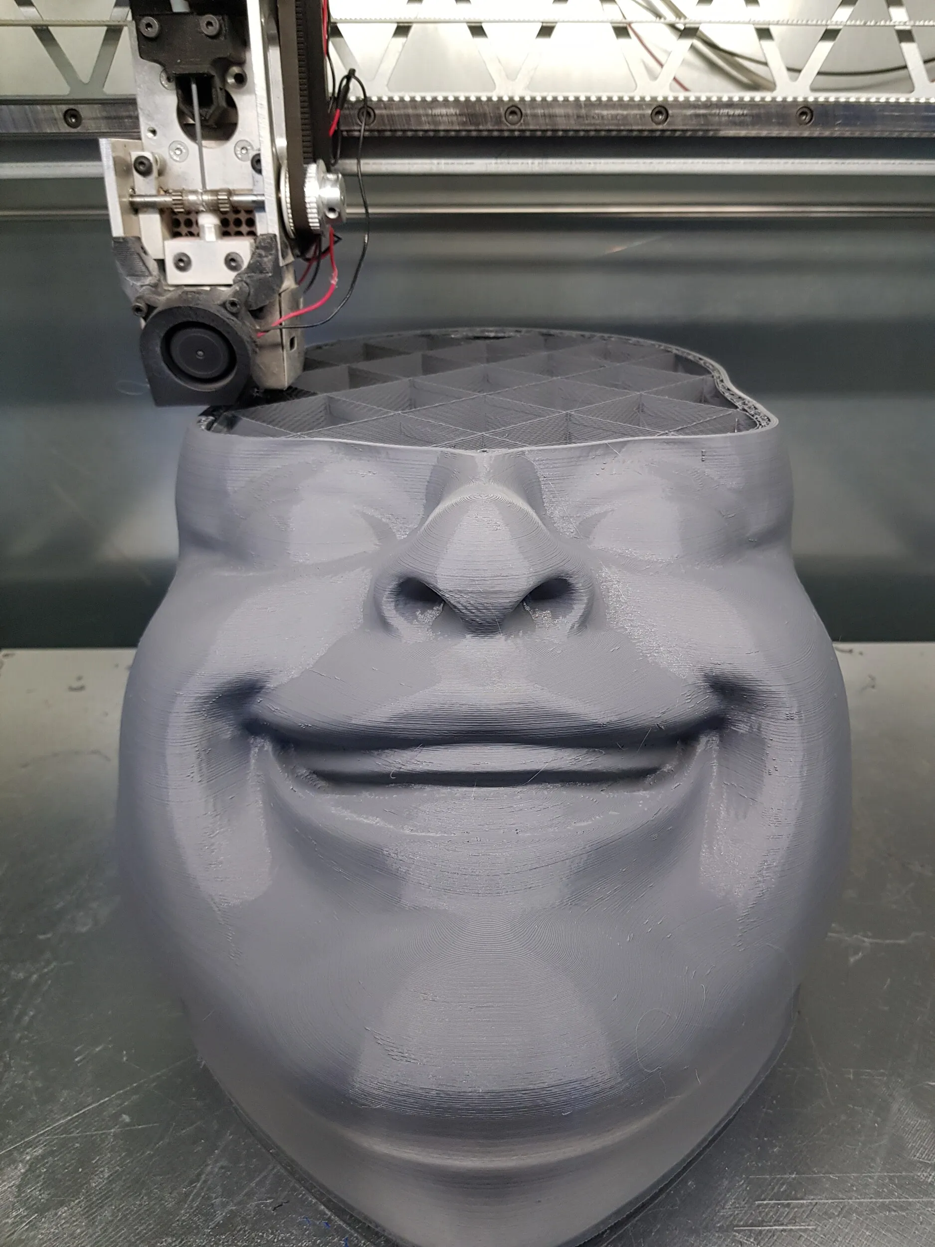 Duży wydruk 3D figury Buddy ustawiony pionowo podczas przymiarki proporcji i skali.