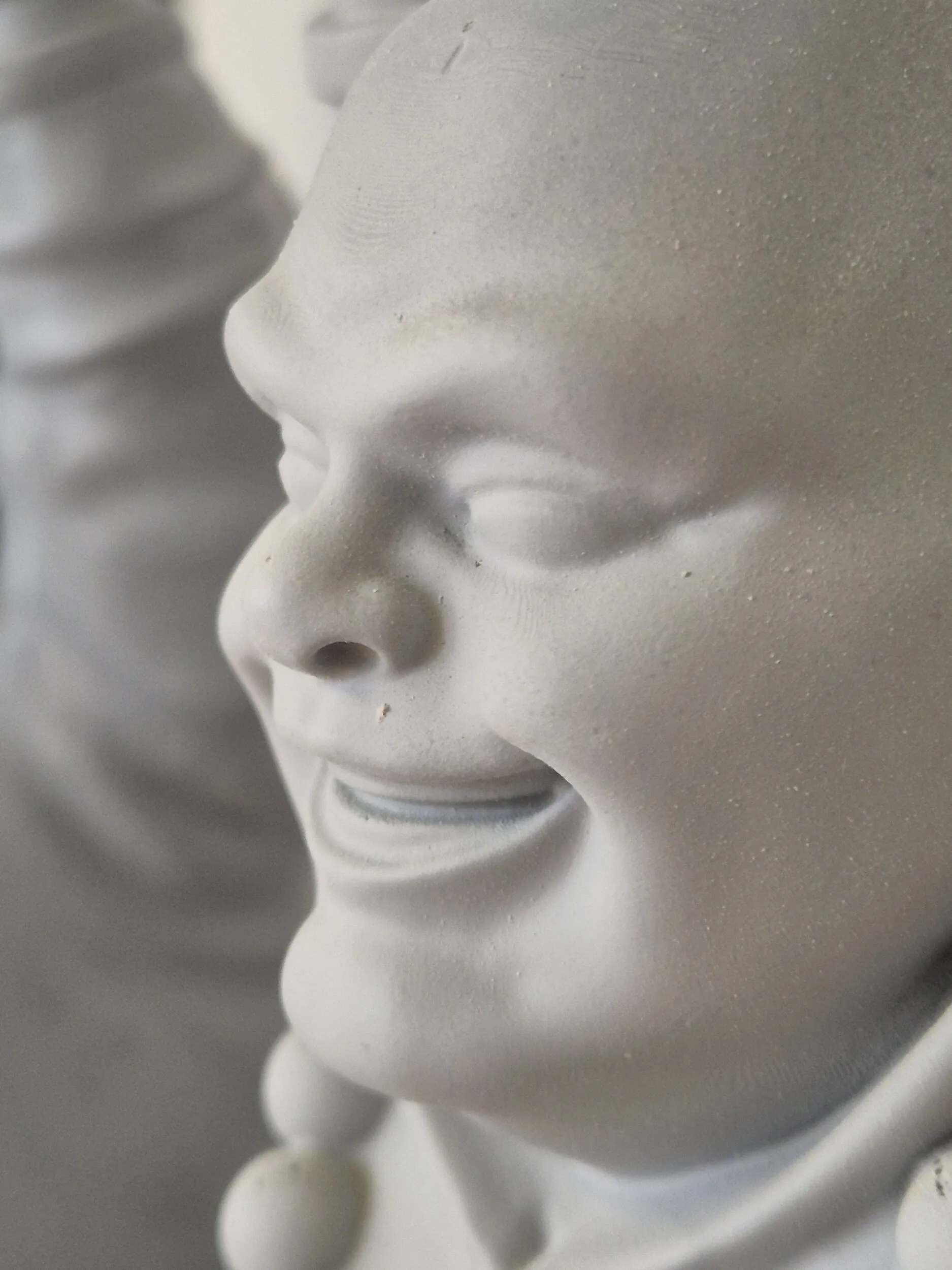 Zbliżenie na gotową powierzchnię wielkoformatowej figury Buddy po malowaniu i wykończeniu.