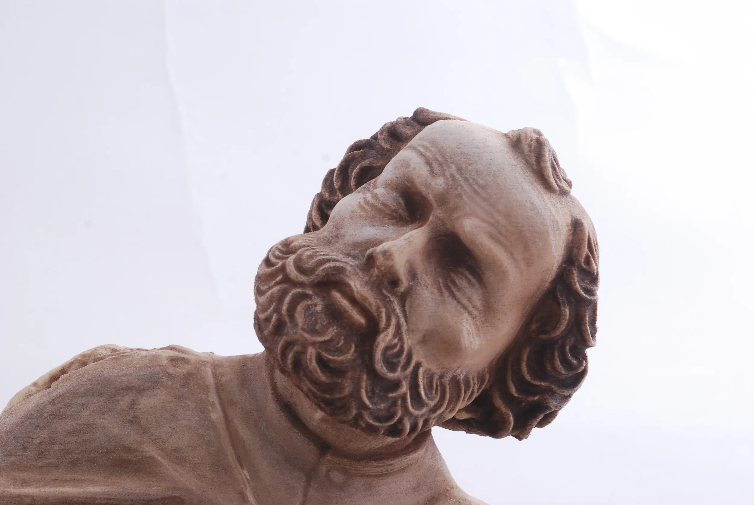 Bliskie ujęcie twarzy i faktury repliki wykonanej z materiału z domieszką drewna.